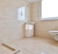 Badezimmer mit Waschbecken und Toilette in einem Einfamilienhaus mit Fliesenverkleidung.