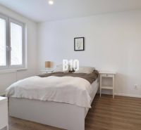 Helles Schlafzimmer mit Holzdekorboden in einer 3-Zimmer-Wohnung mit Einbauschrank.