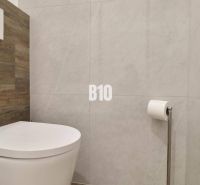 Badezimmer mit Toilette und Holzelementen in einer 3-Zimmer-Wohnung.