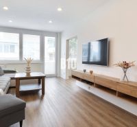 Wohnzimmer in einer 3-Zimmer-Wohnung mit Holzboden und Sofa.