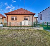 Ein Einfamilienhaus in Sľažany mit Vorgarten und Schrägdach zwischen benachbarten Gebäuden.