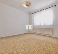Geräumiges Zimmer mit Teppich und Vorhängen in einem Einfamilienhaus.