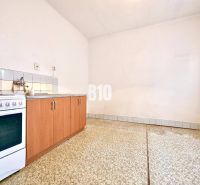 Küche in einem Einfamilienhaus mit Küchenzeile, Herd und Fliesenboden.