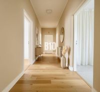 Ein Flur in einem Einfamilienhaus mit einem Holzboden und einer einfachen Einrichtung.