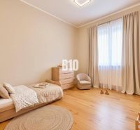 Kinderzimmer mit Bett, Sessel und Kommode, mit Holzboden.