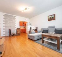Wohnzimmer in einer Zweizimmerwohnung mit Holzboden und gemütlicher Sitzecke.