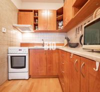 Küche in einer 2-Zimmer-Wohnung mit Holzboden und Schränken.