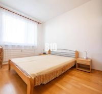 Schlafzimmer in einer 2-Zimmer-Wohnung mit einem Bett und einem Boden in Holzoptik.