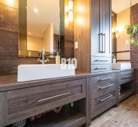 Badezimmer eines Einfamilienhauses mit Schränken und Boden in Holzoptik.