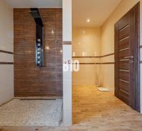 Badezimmer in einem Einfamilienhaus mit Holzboden und Duschkabine.