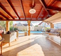 Eine geräumige Terrasse in einem Einfamilienhaus in Nitra mit einem Pool und einer Schaukel.