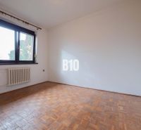 Ein leerer Raum mit Holzboden in einem Einfamilienhaus, großes Fenster.
