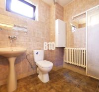 Badezimmer in einem Einfamilienhaus mit Waschbecken, Toilette und Duschkabine. Fliesendekor.