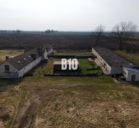 Produktionsstätten in Ture mit älteren Gebäuden, inmitten einer landwirtschaftlichen Landschaft.