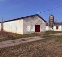 Produktionsräume in Turá mit landwirtschaftlicher Architektur und einem Silo im Hintergrund.