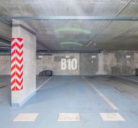 Unterirdischer Parkplatz in Nitra mit markiertem Parkplatz und Betonpfeilern.