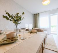 Esstisch in einer 2-Zimmer-Wohnung mit Tischdecken und Dekoration in hellen Farben.