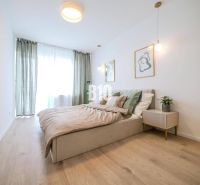 Helles Schlafzimmer in einer 2-Zimmer-Wohnung mit Holzboden und minimalistischen Möbeln.