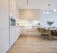 Helle Küche mit Esstisch und Holzboden in einer Zweizimmerwohnung.