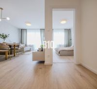 Innenraum einer 2-Zimmer-Wohnung mit Holzboden, Esstisch und Bett.