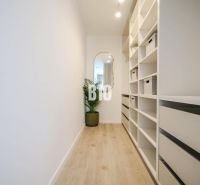 Flur mit Regalen und Spiegel, Boden mit Holzdekor in einer 2-Zimmer-Wohnung.