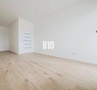 Geräumiges Interieur mit Holzboden und weißen Wänden in einer 2-Zimmer-Wohnung.