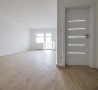 Geräumige helle 2-Zimmer-Wohnung mit Holzboden und weißen Türen.