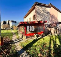 Ein Gebäude in Čadca mit Garten, Terrasse und roter Markise bei sonnigem Wetter.