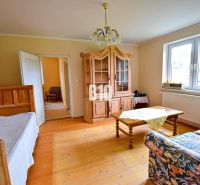 Wohnzimmer mit Sofa, Schrank und Holzboden in einem Einfamilienhaus.