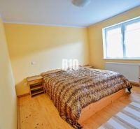 Ein Schlafzimmer mit Doppelbett, Holzmöbeln und einem Boden mit Holzdekor in einem Einfamilienhaus.
