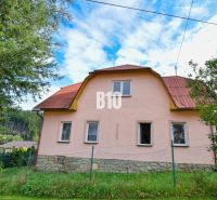 Ein Einfamilienhaus in Makov mit einem Steinfundament und einem roten Dach, umgeben von Grün.