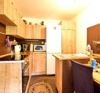 Eine Küche in einer Hütte mit Holzdekor und rustikalen Schränken.