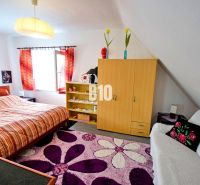 Gemütliches Schlafzimmer in einer Hütte mit einem bunten Teppich, einem Schrank und einem Doppelbett.