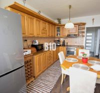 Küche in einer 3-Zimmer-Wohnung mit einer Eckküche und einem Boden in Holzoptik.