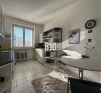 Küche in einer 2-Zimmer-Wohnung mit weißen Schränken, Fenster und Esstisch.