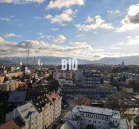 Die Stadt Žilina mit Panorama, Wohnhäuser und Industriegebiet im Vordergrund.