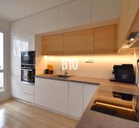 Küche einer 3-Zimmer-Wohnung mit Holzboden und eingebauten Geräten.