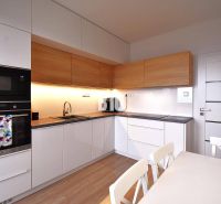 Küche einer 3-Zimmer-Wohnung mit Holzelementen und Geräten, einschließlich Backofen und Kochfeld.