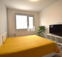 Schlafzimmer in einer 3-Zimmer-Wohnung mit Bett, Fernseher und Holzboden.