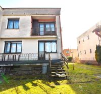 Ein Einfamilienhaus in Žilina mit Terrasse, Rasen und Treppen, die zum Garten führen.