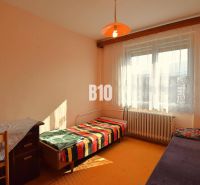 Ein Zimmer in einem Einfamilienhaus mit einfacher Einrichtung, einem Bett und einer orangefarbenen Laterne.