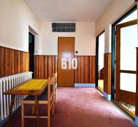 Der Flur in einem Einfamilienhaus mit Holzverkleidung, Tisch und Stuhl.