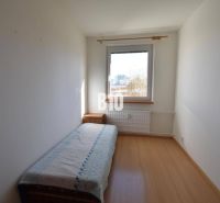 Ein Zimmer mit einem Einzelbett, einem Nachttisch und einem Boden mit Holzdekor in einer Wohnung mit 5 oder mehr Zimmern.