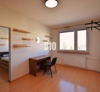 Ein Arbeitszimmer mit Regalen, einem Tisch und einem Boden mit Holzdekor in einer Wohnung mit 5 oder mehr Zimmern.