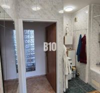 Badezimmer mit Duschkabine, weißen Fliesen und dunklem Boden in einer Wohnung mit 5 oder mehr Zimmern.