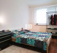 Helles Schlafzimmer in einer 4-Zimmer-Wohnung mit Bett und Boden in Holzoptik.