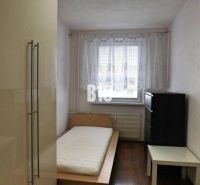 Einfach eingerichtetes Zimmer mit einem Einzelbett und Holzboden in einer 4-Zimmer-Wohnung.