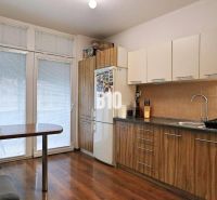 Küche in einer 4-Zimmer-Wohnung mit Holzboden und Essecke.