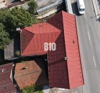 Das Dach des Gebäudes in Belá und die Straße mit Autos aus der Vogelperspektive.