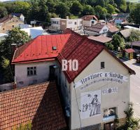 Gasthaus in Belej mit rotem Dach und Wandgemälde eines Mannes mit Bier.